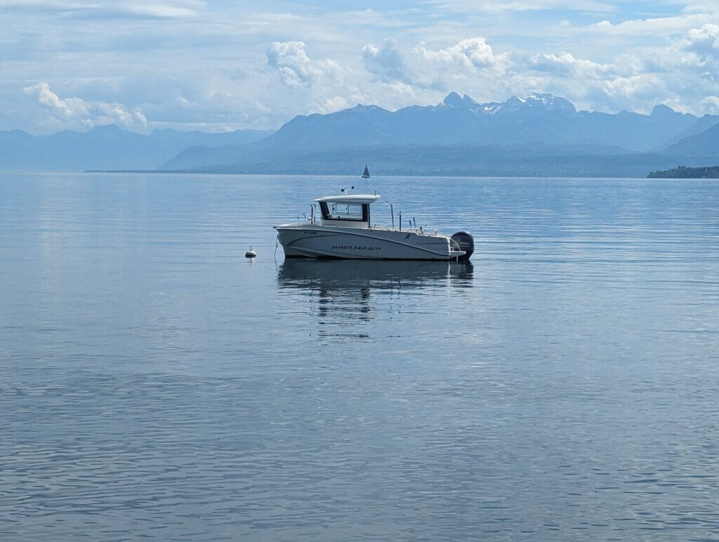 A small, solitary fishing boat on Lake Geneva, Switzerland.